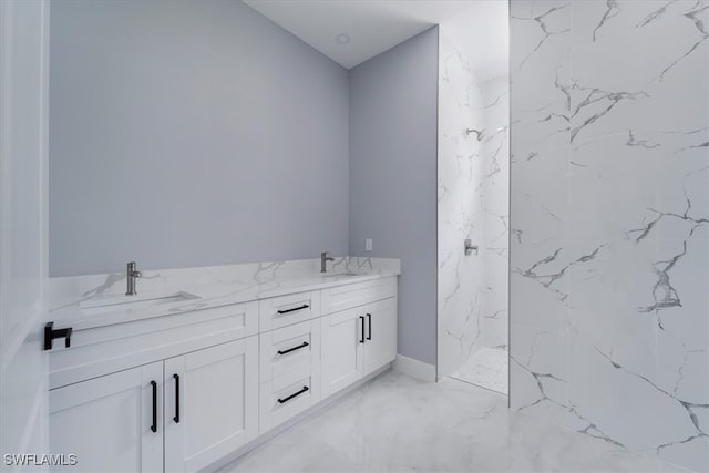 bathroom with a tile shower and vanity