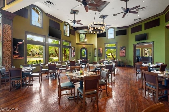 dining area with a chandelier, a towering ceiling, and wood-type flooring