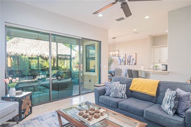 living room featuring light tile patterned flooring and ceiling fan with notable chandelier