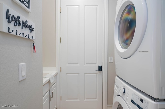 laundry room featuring stacked washer / drying machine