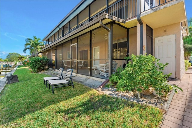 exterior space featuring a balcony and a lawn