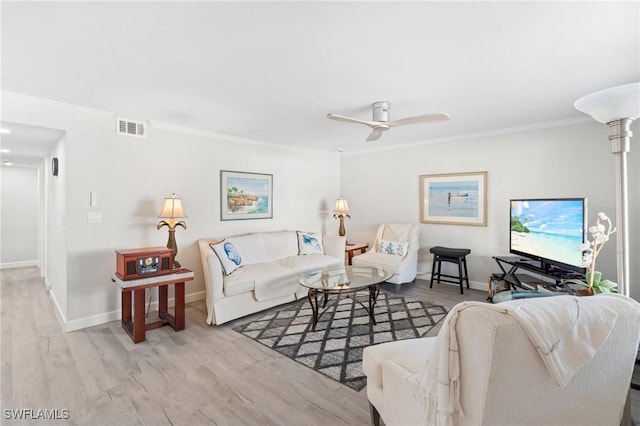 living room featuring decorative columns, crown molding, ceiling fan, and light hardwood / wood-style floors