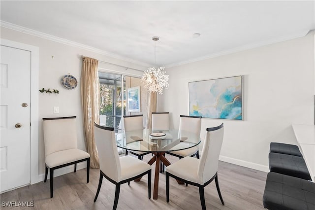 dining space with crown molding, hardwood / wood-style floors, and an inviting chandelier