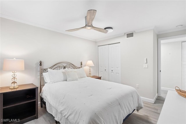 bedroom with ceiling fan, wood-type flooring, ornamental molding, and a closet