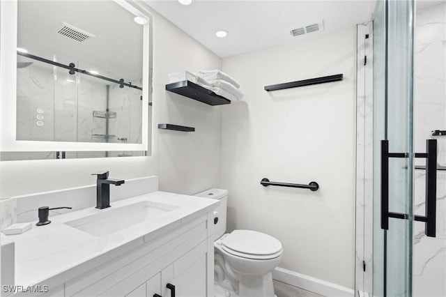 bathroom with vanity, a shower with shower door, and toilet