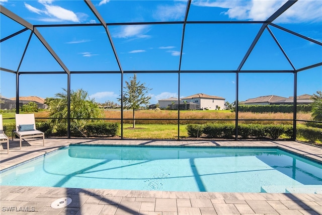 view of pool with a patio and glass enclosure