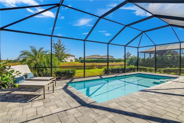 view of swimming pool featuring glass enclosure and a patio area