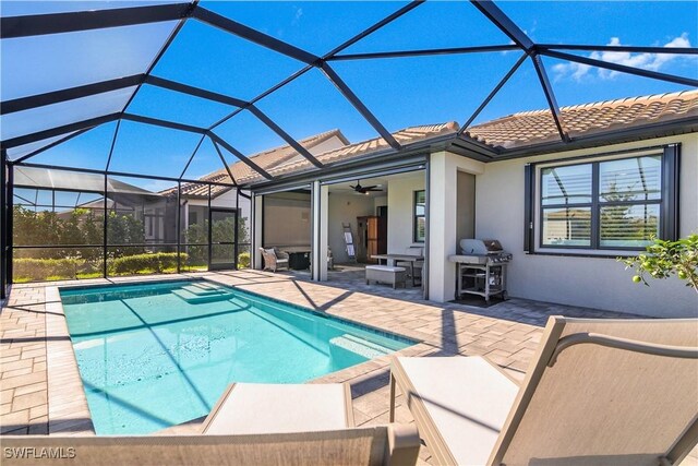 view of pool featuring a patio, area for grilling, ceiling fan, and a lanai