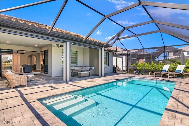 view of swimming pool featuring an outdoor hangout area, glass enclosure, ceiling fan, and a patio area