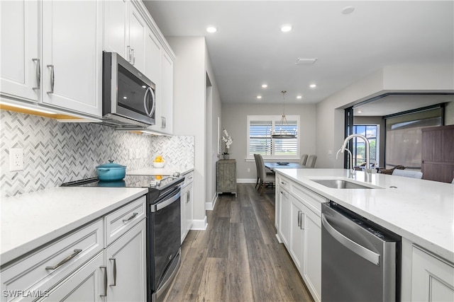 kitchen with stainless steel appliances, dark wood-type flooring, sink, decorative light fixtures, and white cabinets