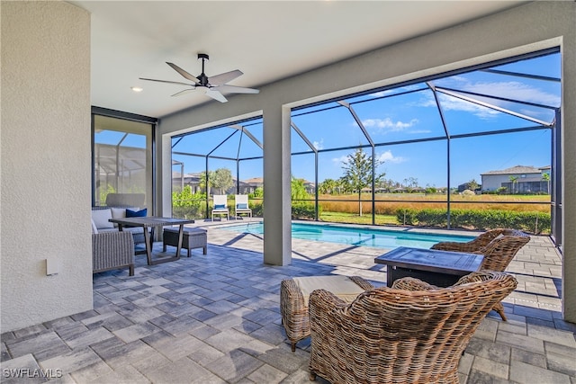 view of patio featuring glass enclosure and ceiling fan