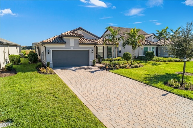 mediterranean / spanish-style house with a garage and a front lawn