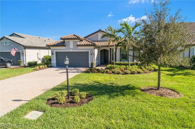 mediterranean / spanish home featuring a garage and a front yard