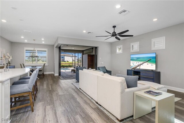 living room featuring ceiling fan and light wood-type flooring