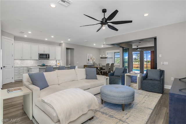 living room with ceiling fan, french doors, and light hardwood / wood-style flooring