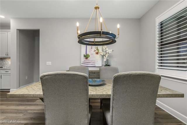 dining space featuring dark hardwood / wood-style flooring and a chandelier