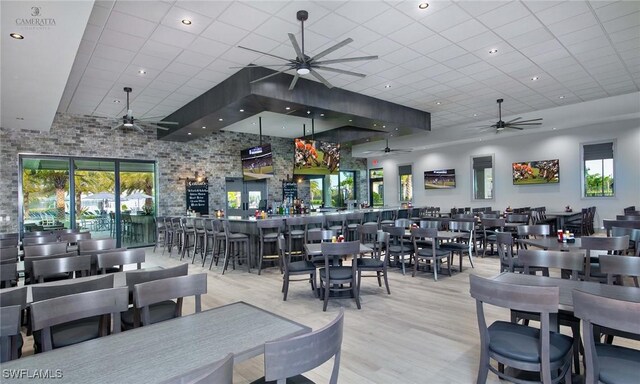 dining space featuring light hardwood / wood-style flooring and a drop ceiling