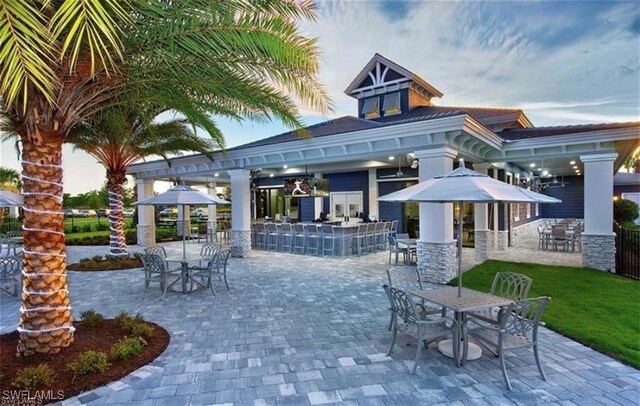 patio terrace at dusk featuring a gazebo and exterior bar