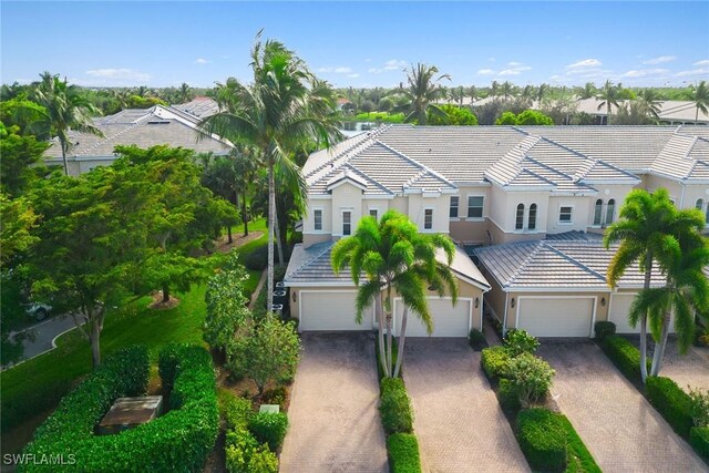3053 Aviamar Cir Unit 101, Naples, FL 34114 - view of front facade with stucco siding, decorative driveway, a tile roof, and a garage