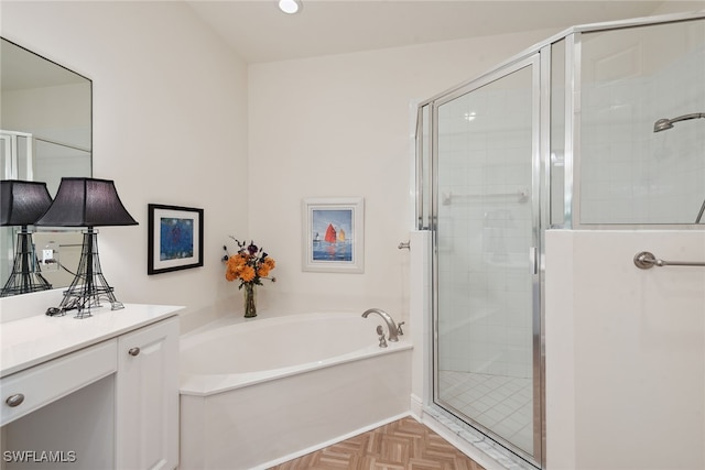 bathroom featuring parquet floors, vanity, and plus walk in shower