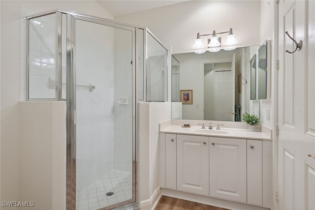 bathroom with wood-type flooring, vanity, and walk in shower