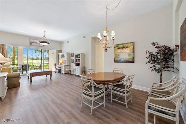 dining room with hardwood / wood-style floors and a notable chandelier