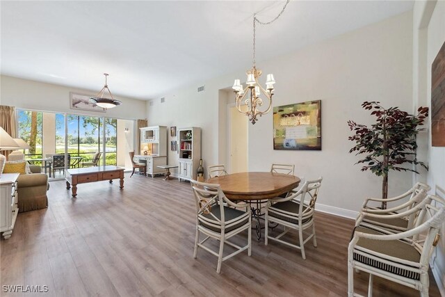 3053 Aviamar Cir Unit 101, Naples, FL 34114 - dining room with wood finished floors, a chandelier, and baseboards