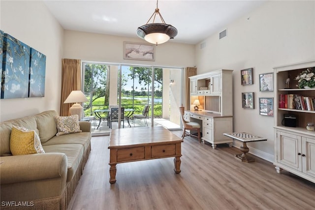 3053 Aviamar Cir Unit 101, Naples, FL 34114 - living area with light wood-style floors, baseboards, and a towering ceiling