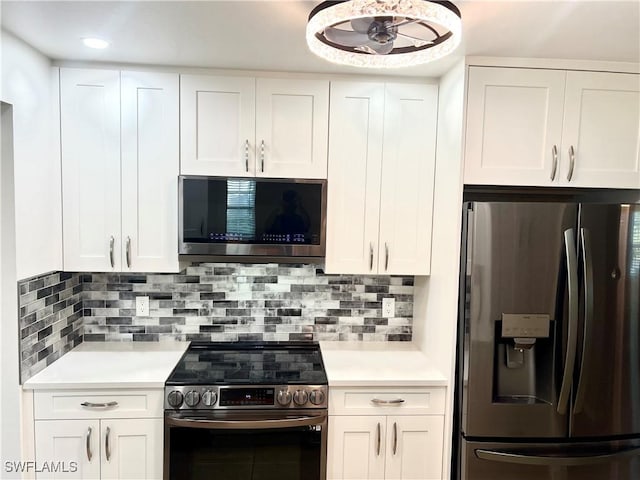 kitchen with stainless steel appliances, white cabinets, and decorative backsplash