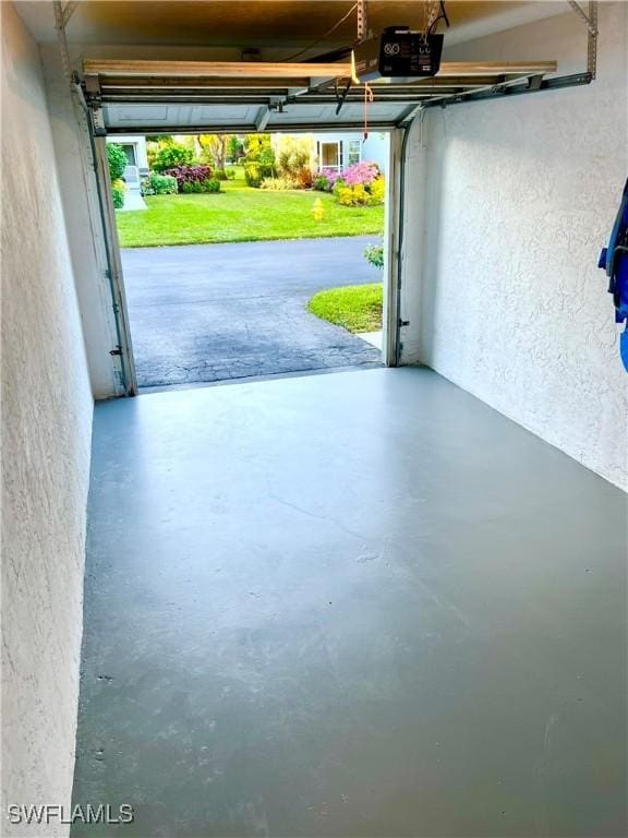 garage featuring a garage door opener and a lawn