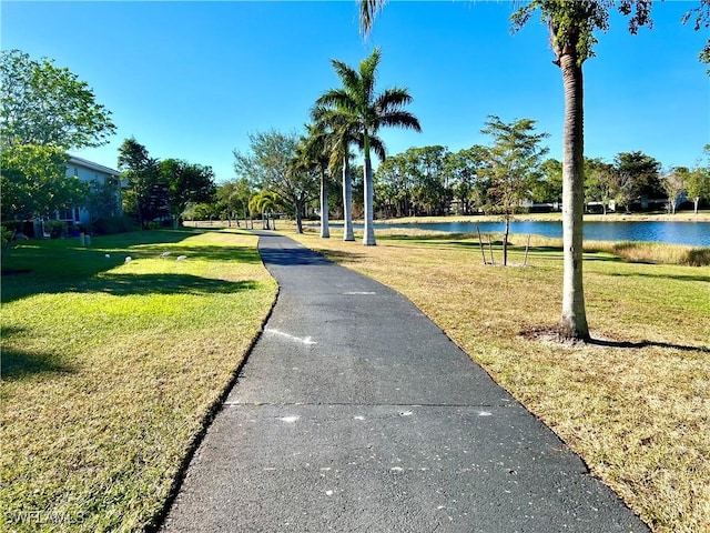 view of home's community with a water view and a yard