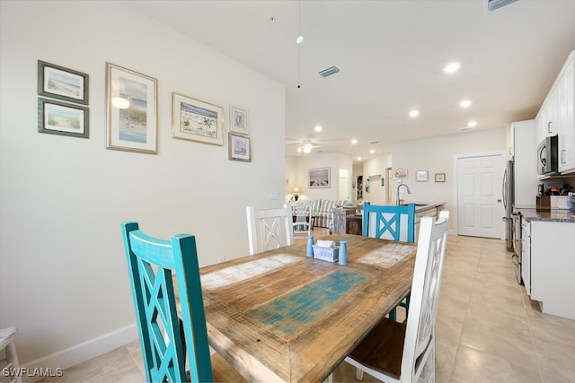 dining space featuring light tile patterned flooring, ceiling fan, and sink