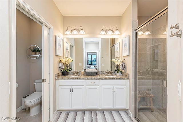 bathroom with vanity, toilet, and a shower with door