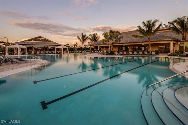 pool at dusk with a patio area