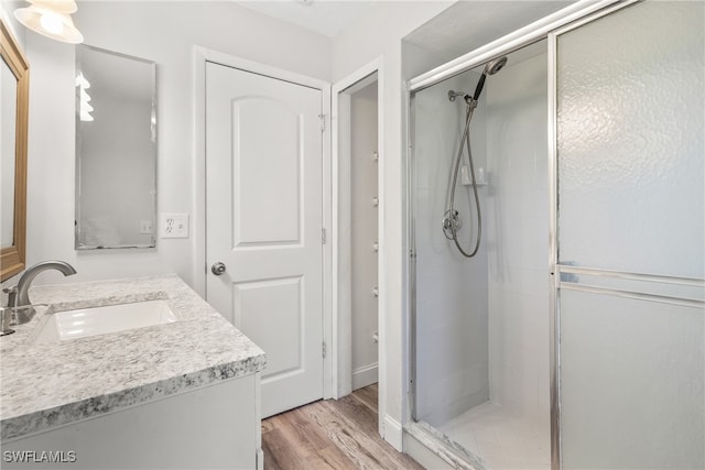 bathroom featuring hardwood / wood-style floors, vanity, and an enclosed shower