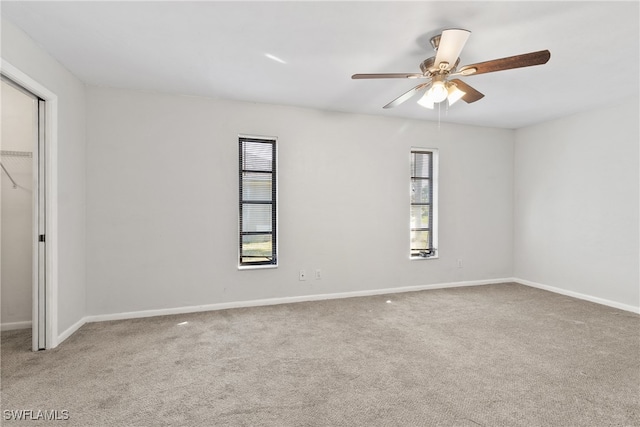 unfurnished room featuring light colored carpet, ceiling fan, and a healthy amount of sunlight