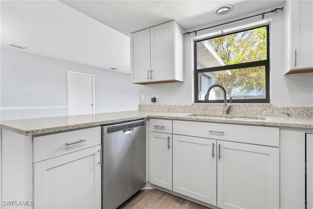 kitchen with white cabinetry, sink, stainless steel dishwasher, kitchen peninsula, and light hardwood / wood-style floors