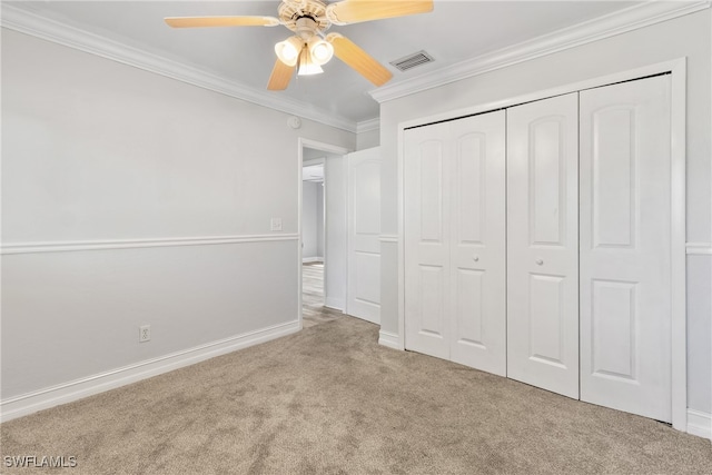 unfurnished bedroom featuring a closet, light colored carpet, ceiling fan, and ornamental molding