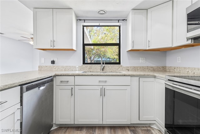 kitchen with white cabinets, hardwood / wood-style flooring, sink, and appliances with stainless steel finishes