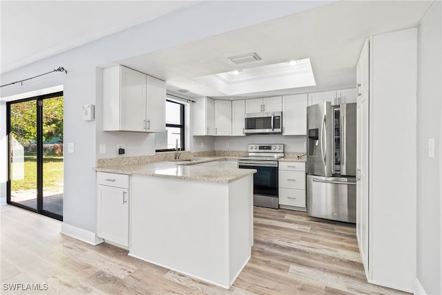 kitchen featuring white cabinets, a healthy amount of sunlight, stainless steel appliances, and light hardwood / wood-style flooring