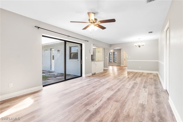 unfurnished living room with ceiling fan with notable chandelier and light hardwood / wood-style flooring