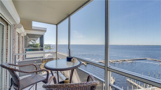 sunroom featuring a water view