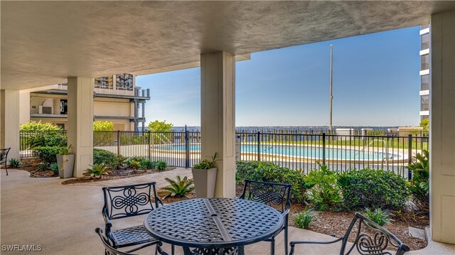 view of patio / terrace featuring fence and a community pool