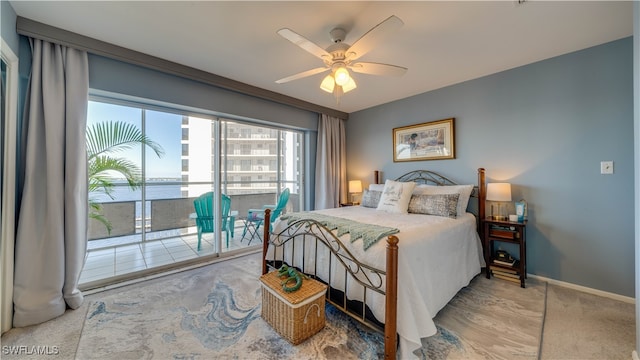 carpeted bedroom featuring access to outside, ceiling fan, and a water view