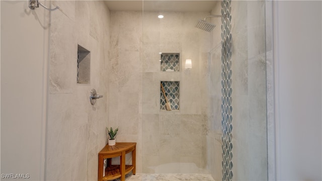 bathroom with a tile shower and tile walls