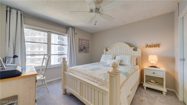 bedroom with a textured ceiling, ceiling fan, baseboards, and light colored carpet