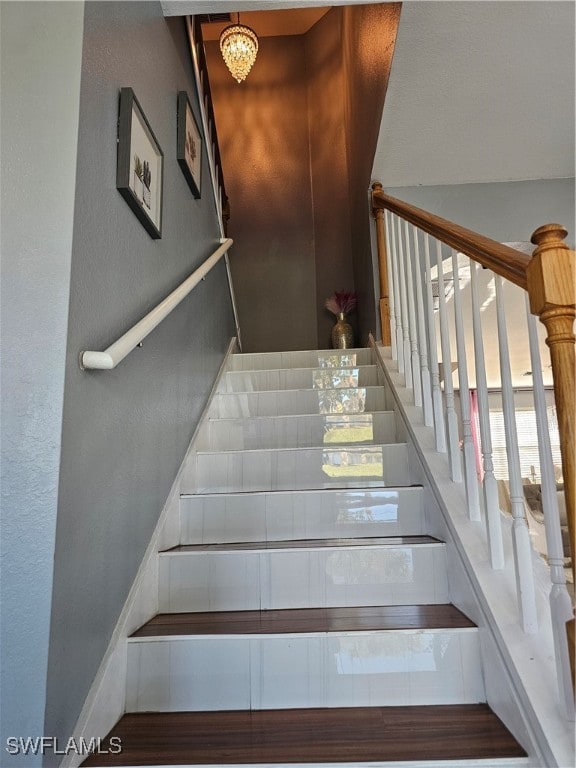 staircase featuring an inviting chandelier