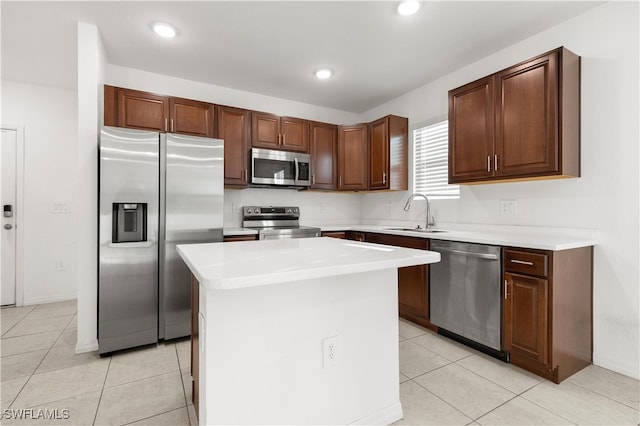 kitchen featuring a kitchen island, light tile patterned floors, sink, and appliances with stainless steel finishes