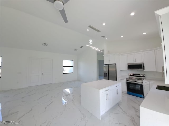 kitchen featuring a center island, lofted ceiling, white cabinets, decorative light fixtures, and stainless steel appliances