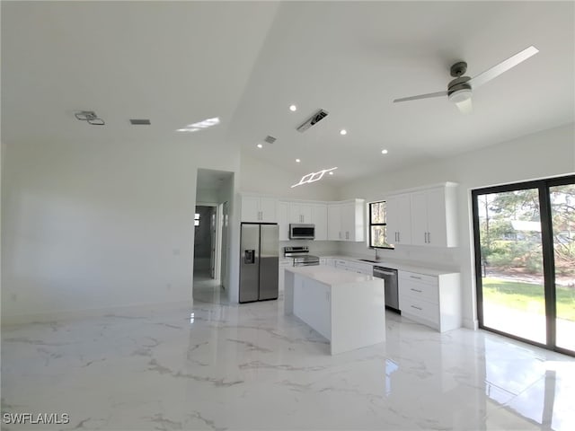 kitchen with appliances with stainless steel finishes, white cabinetry, a kitchen island, and sink